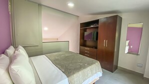 A bedroom with a bed, a wardrobe, a mirror, and a sliding door. - Bugio Flats (Angra dos Reis)