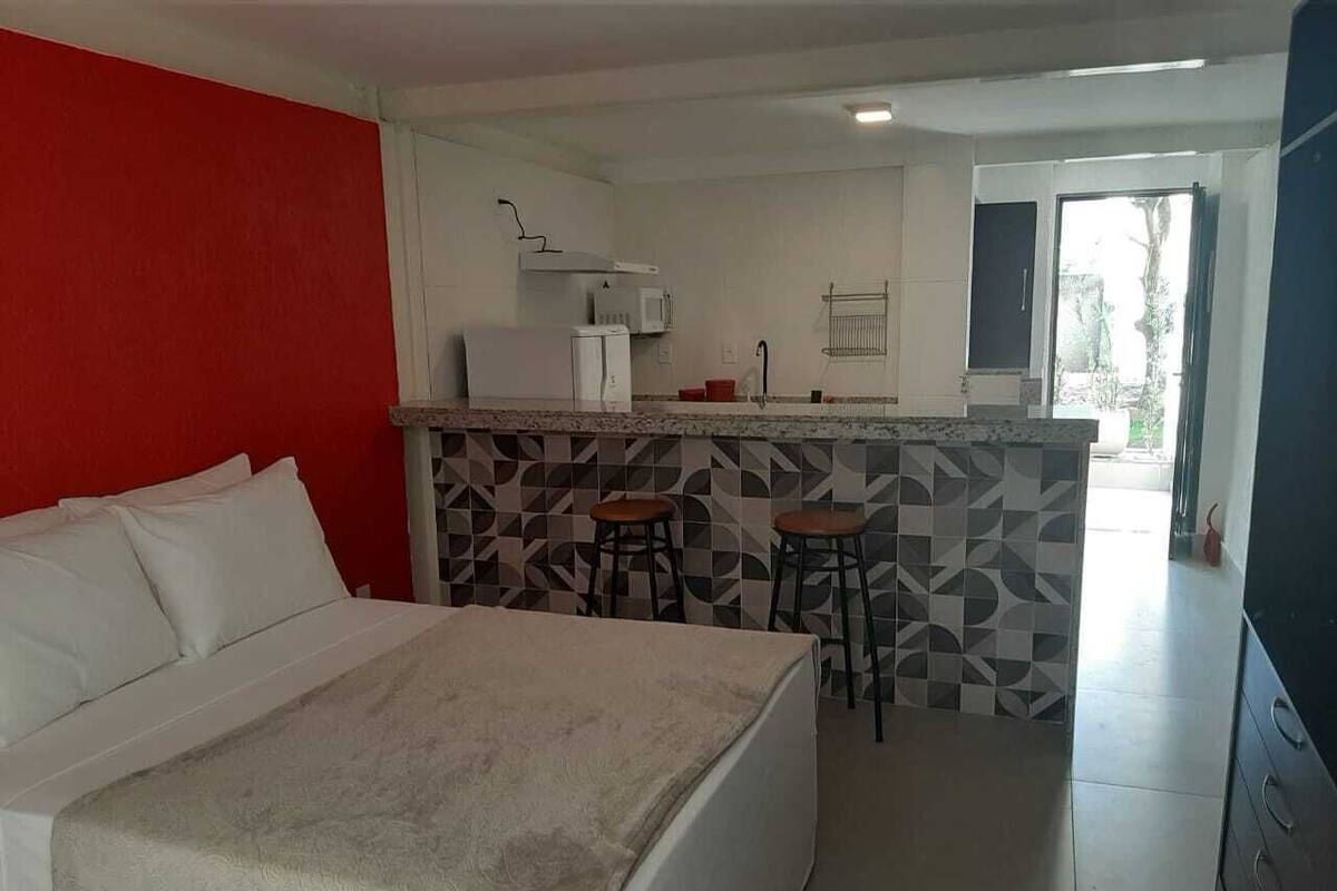 Une chambre d’hôtel comprenant un lit, une kitchenette et une salle de bain.