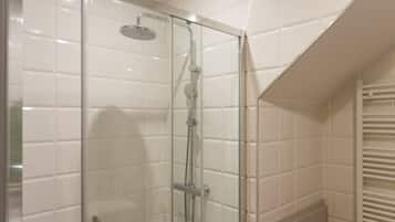 Ducha con cerramiento de vidrio, cabezal de ducha de mano, grifo empotrado y panel de control.