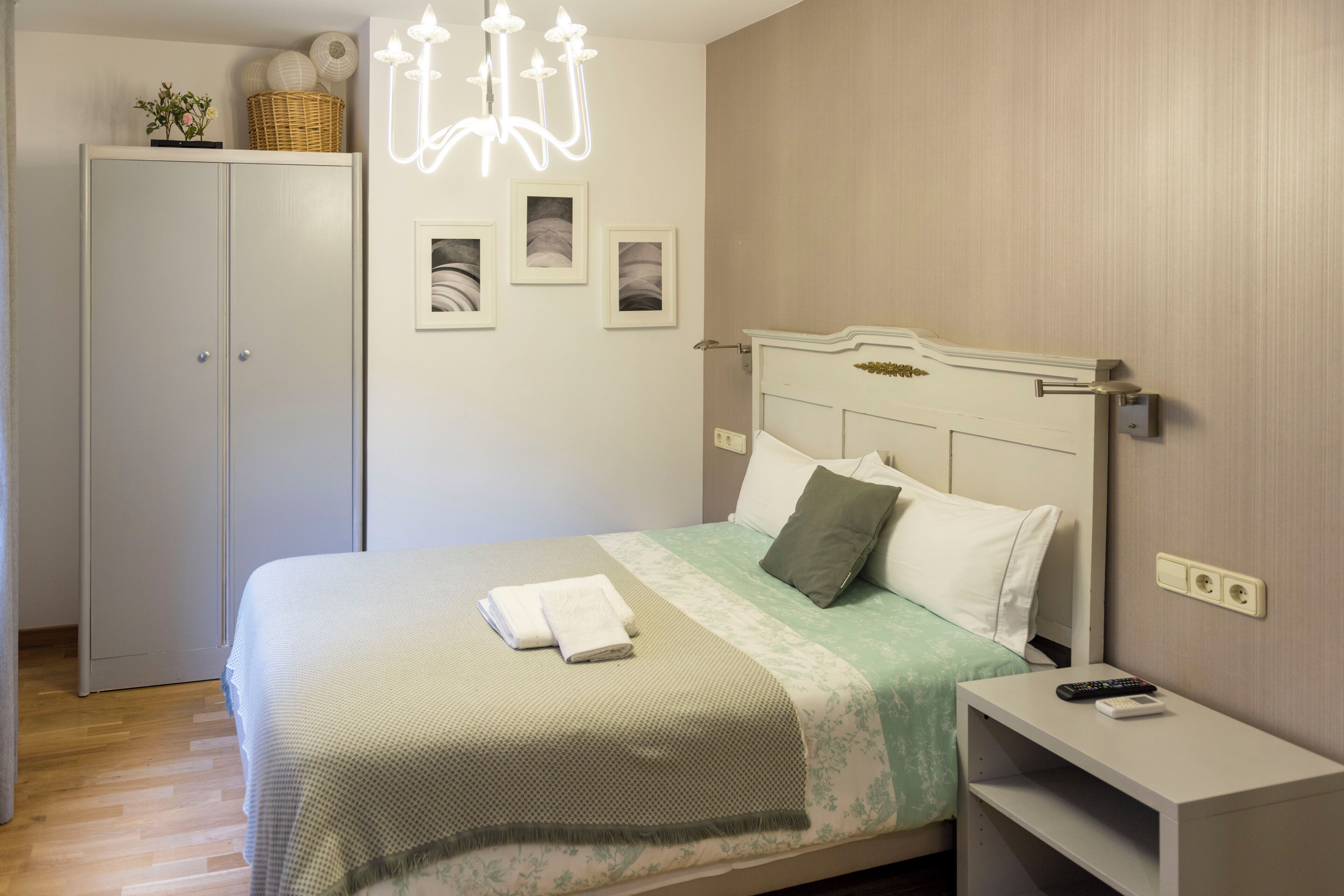 Un dormitorio ordenado con cama, mesita de noche y armario.