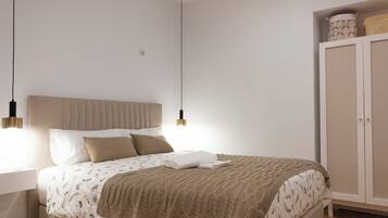 A bedroom with a bed, bedside table, wardrobe, and pendant lights.