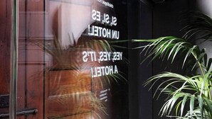 A hotel window with a reflection of a person and text reading "UNHOTEL A YESTERDAY". - Basic Hotel (Olerdola)