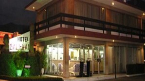 A hotel with a glass facade, outdoor seating area, and a sign indicating it is a hotel in Bali. - Bali Hai (Acapulco)