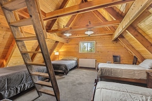A loft-style bedroom with wooden beams, two beds, a ladder, a window, and a radiator. - Holden Hideaway - 23 miles to YNP ~ Outdoor kitchen ~ Firepit ~ Wifi (Island Park)