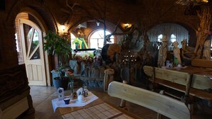 A rustic interior with wooden benches, stone walls, and a fireplace. - Hotel Staropolski (Tomaszow Lubelski)