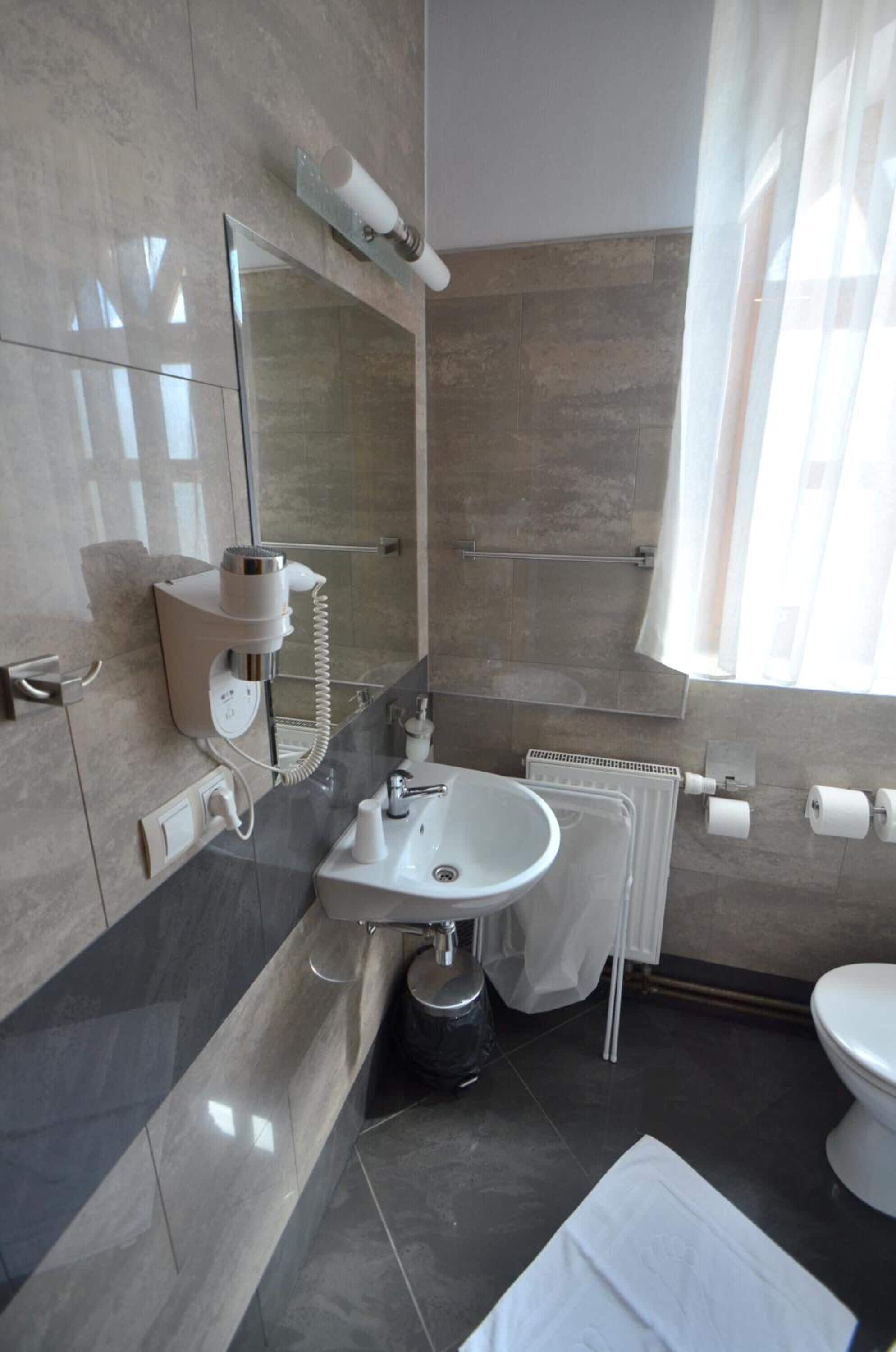 Une salle de bain moderne avec une douche à parois de verre, un lavabo intégré, un porte-serviettes et des toilettes.