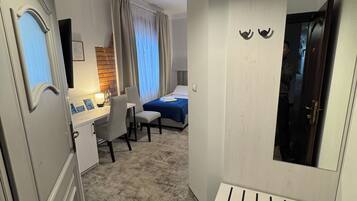 Ein Hotelzimmer mit Schreibtisch, Stuhl, Bett und Spiegel.