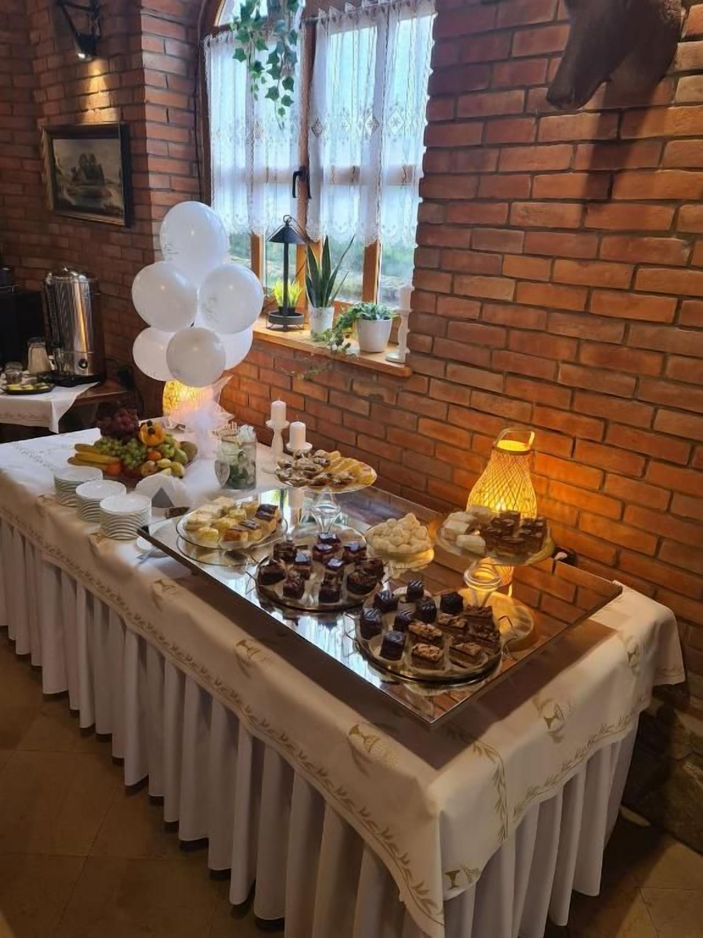 Egy étteremben felállított svédasztal, melyen különféle ételek találhatók, és amelyet dekoratív lufikból álló díszítés egészít ki.