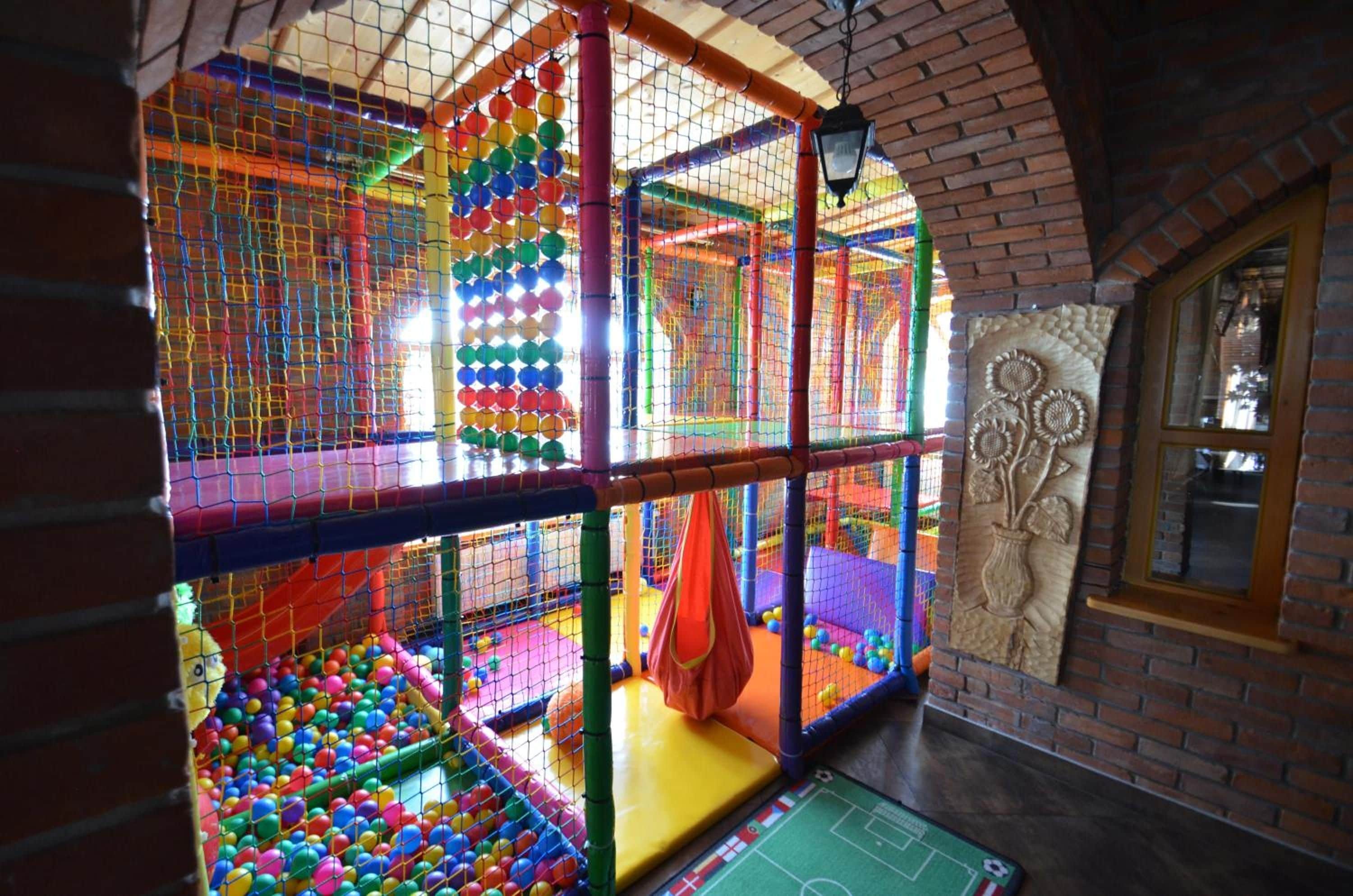 A multi-level play area with colorful netted structures and a soccer field.