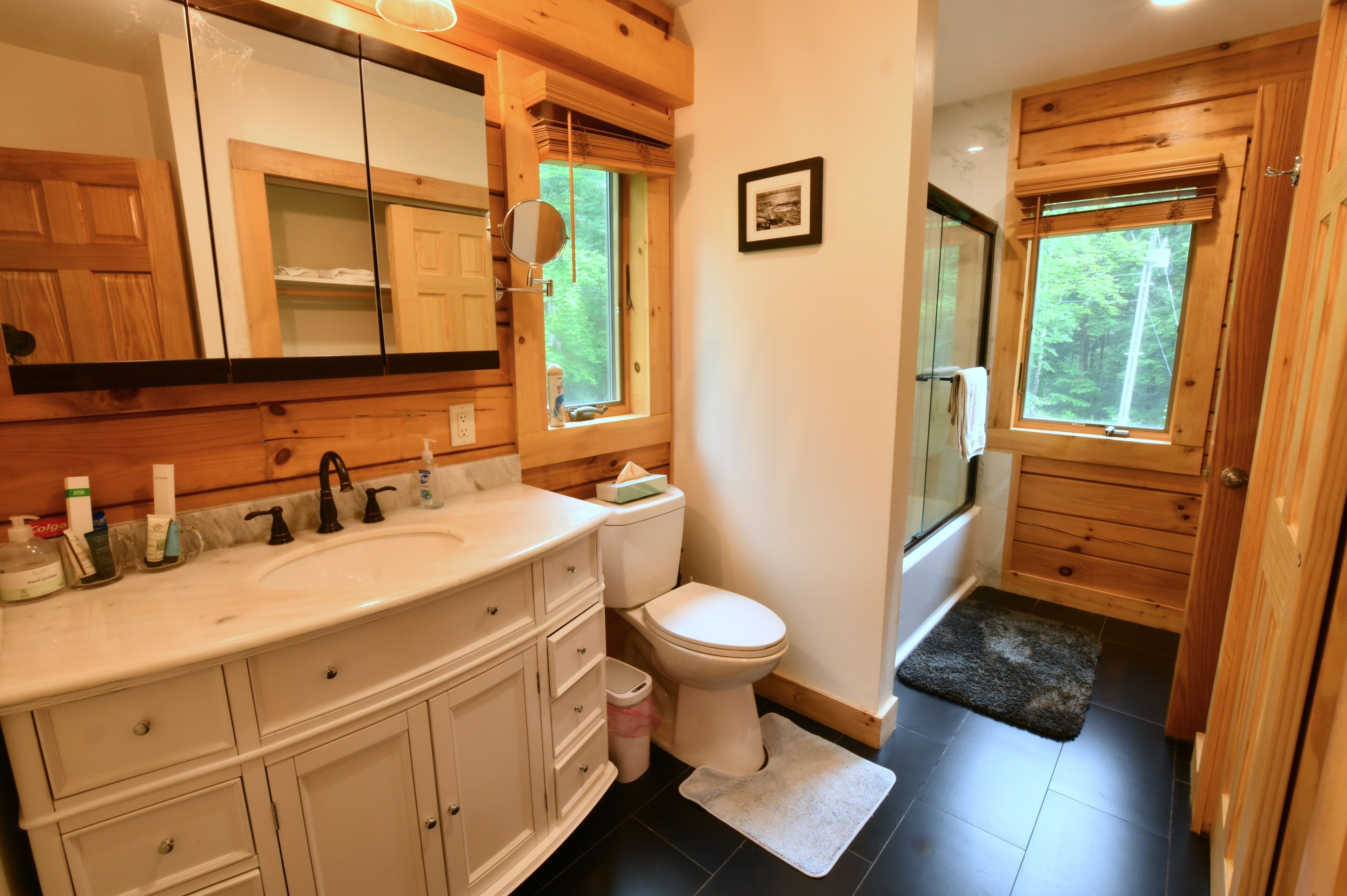 A bathroom with wooden cabinets, a white sink, and a toilet.