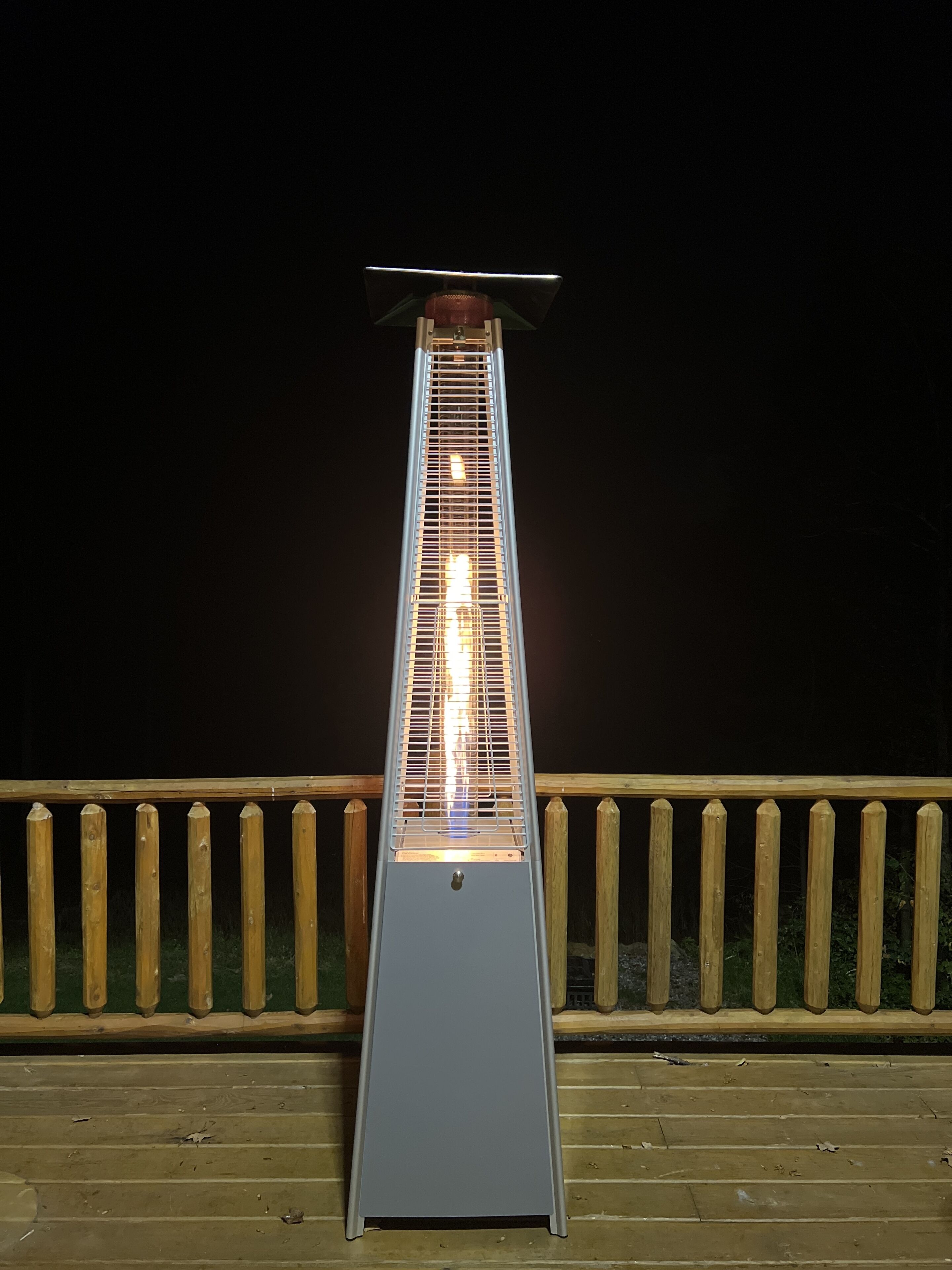 Un grand radiateur d’extérieur rectangulaire, doté d’une structure métallique et d’un dessus plat, placé sur une terrasse en bois pourvue d’une rambarde.
