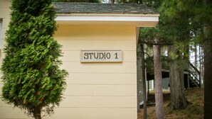 Ein Gebäude mit der Aufschrift "STUDIO 1" und einem kleinen Baum davor.