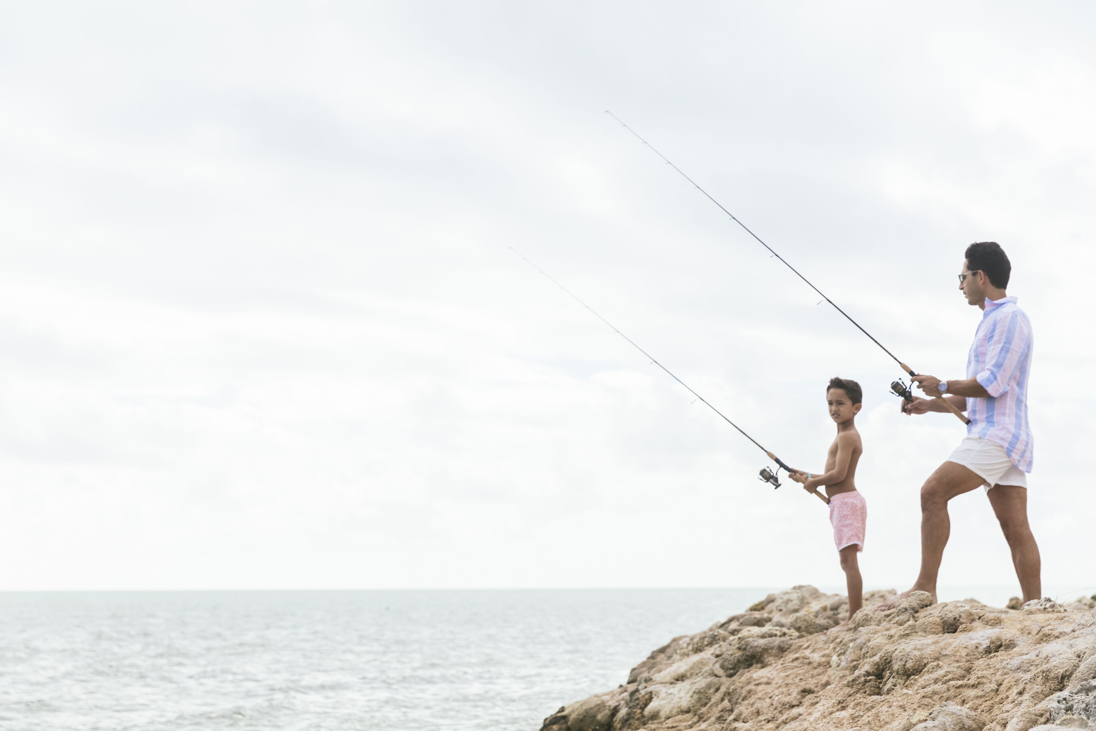 Deux personnes sont en train de pêcher au bord de la mer.