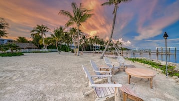 Di pantai, kursi berjemur, payung pantai, dan handuk pantai