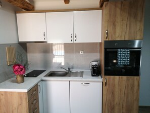 Enjoy cooking and preparing beverages in this kitchen with oven, coffee maker, and sink.