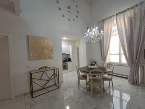 A dining area with a chandelier, a round table, and chairs. There is a kitchen in the background. - New apartment near the Duomo with Wi-Fi and an elevator (Firenze)