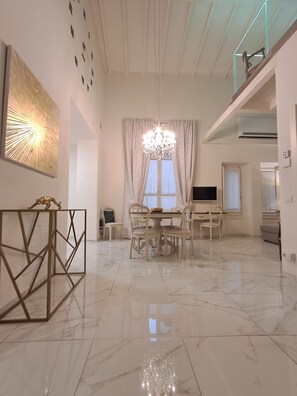 A spacious living area with a chandelier, a dining table, and a TV. - New apartment near the Duomo with Wi-Fi and an elevator (Firenze)