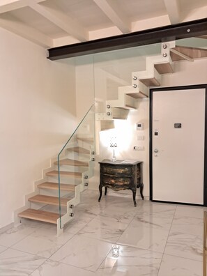 A modern interior with a glass staircase, a wooden floor, and a white door. - New apartment near the Duomo with Wi-Fi and an elevator (Firenze)