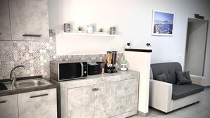 A compact kitchen with a microwave, coffee maker, and small potted plants on a shelf. - B&B Rianna House (Naples)