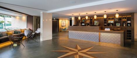 Um lobby moderno com balcão de recepção, área de estar e um grande design de piso em formato de estrela.