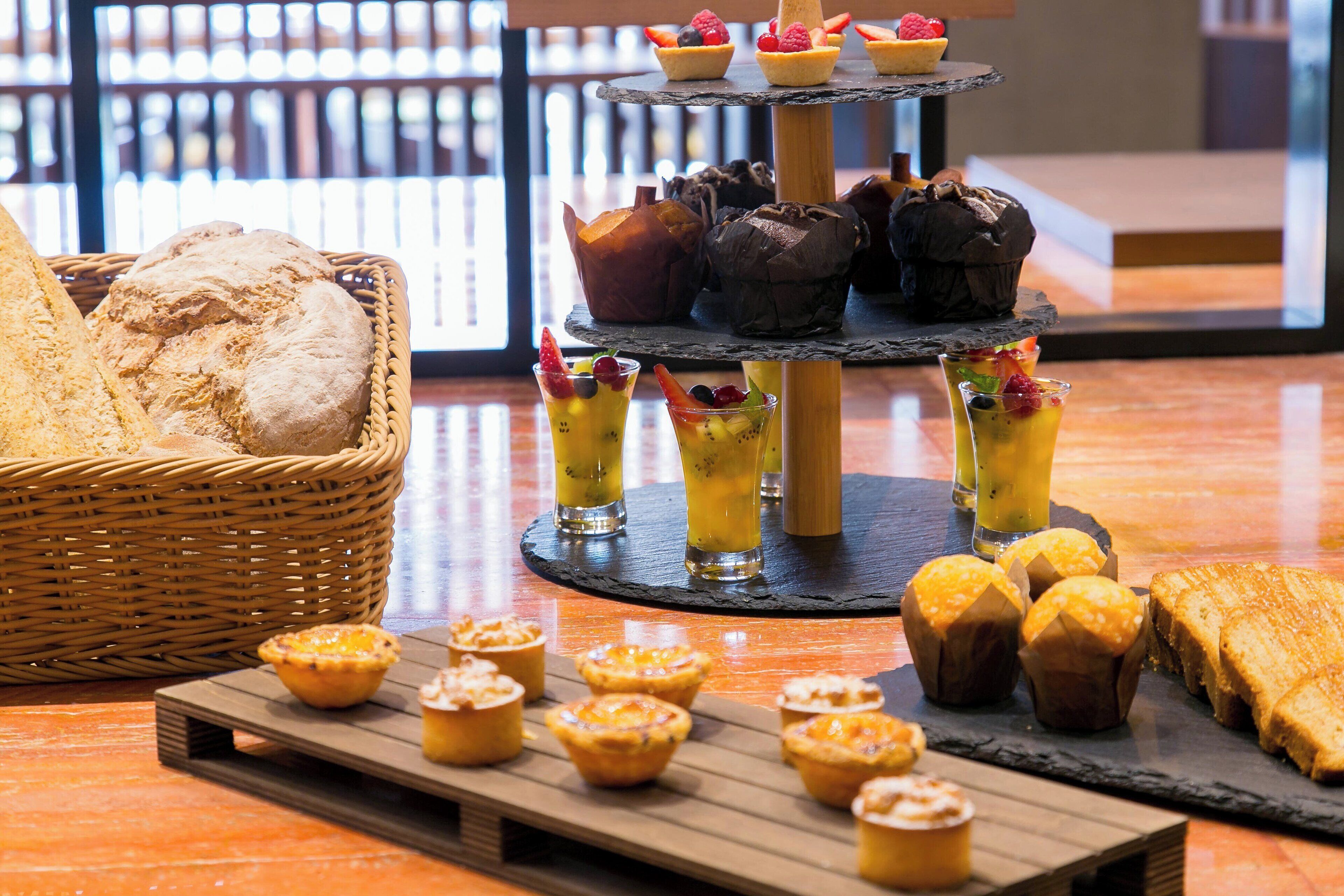 A multi-tiered dessert display with various pastries and fruit drinks.