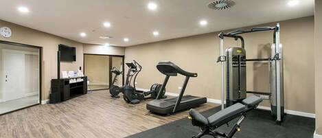 A gym with treadmills, elliptical machines, and weightlifting equipment.