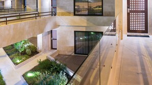 Un bâtiment moderne doté d’une cour intérieure, de portes vitrées et d’un escalier.