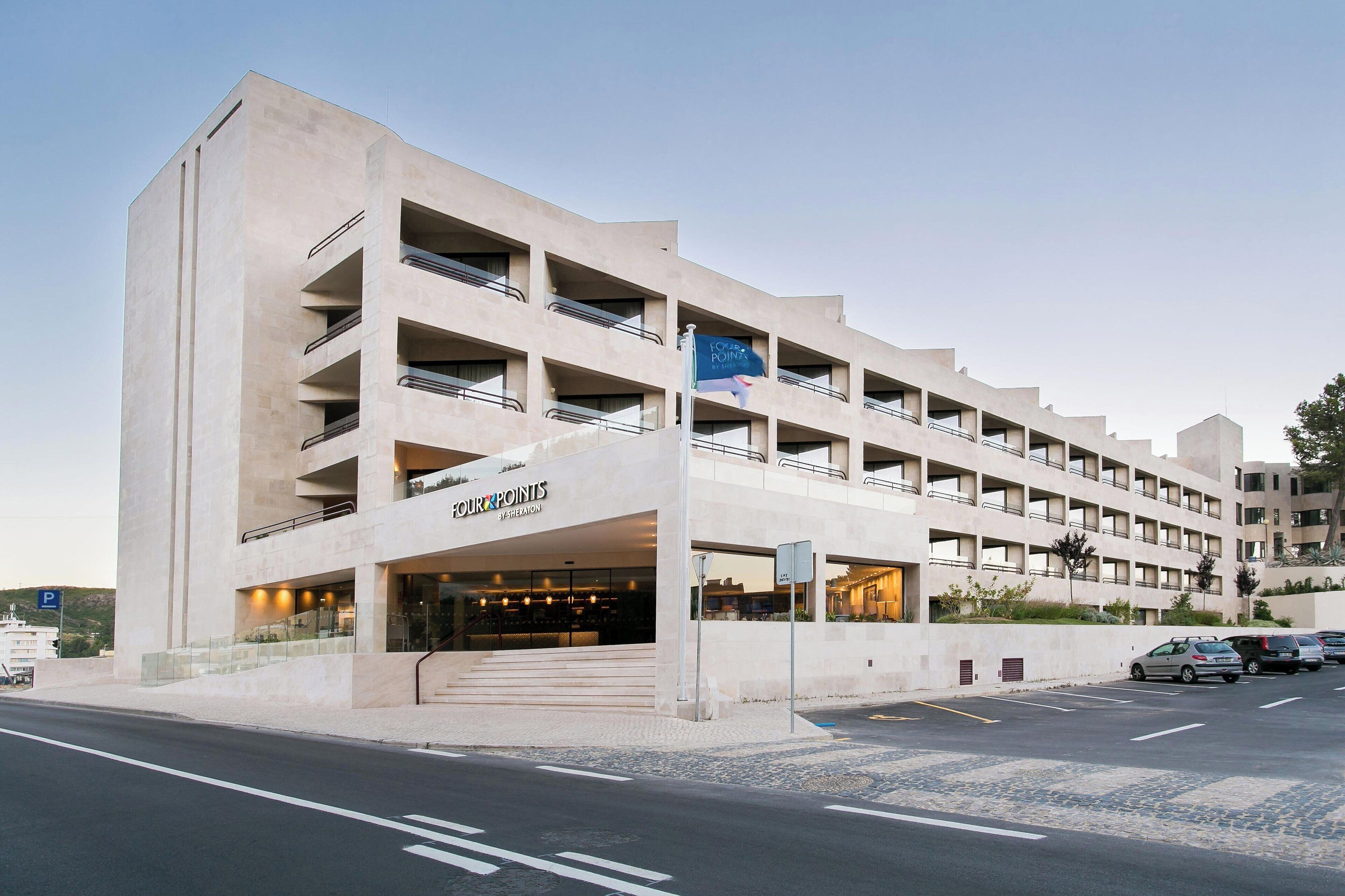A multi-story hotel with a modern design, featuring balconies and a prominent entrance.