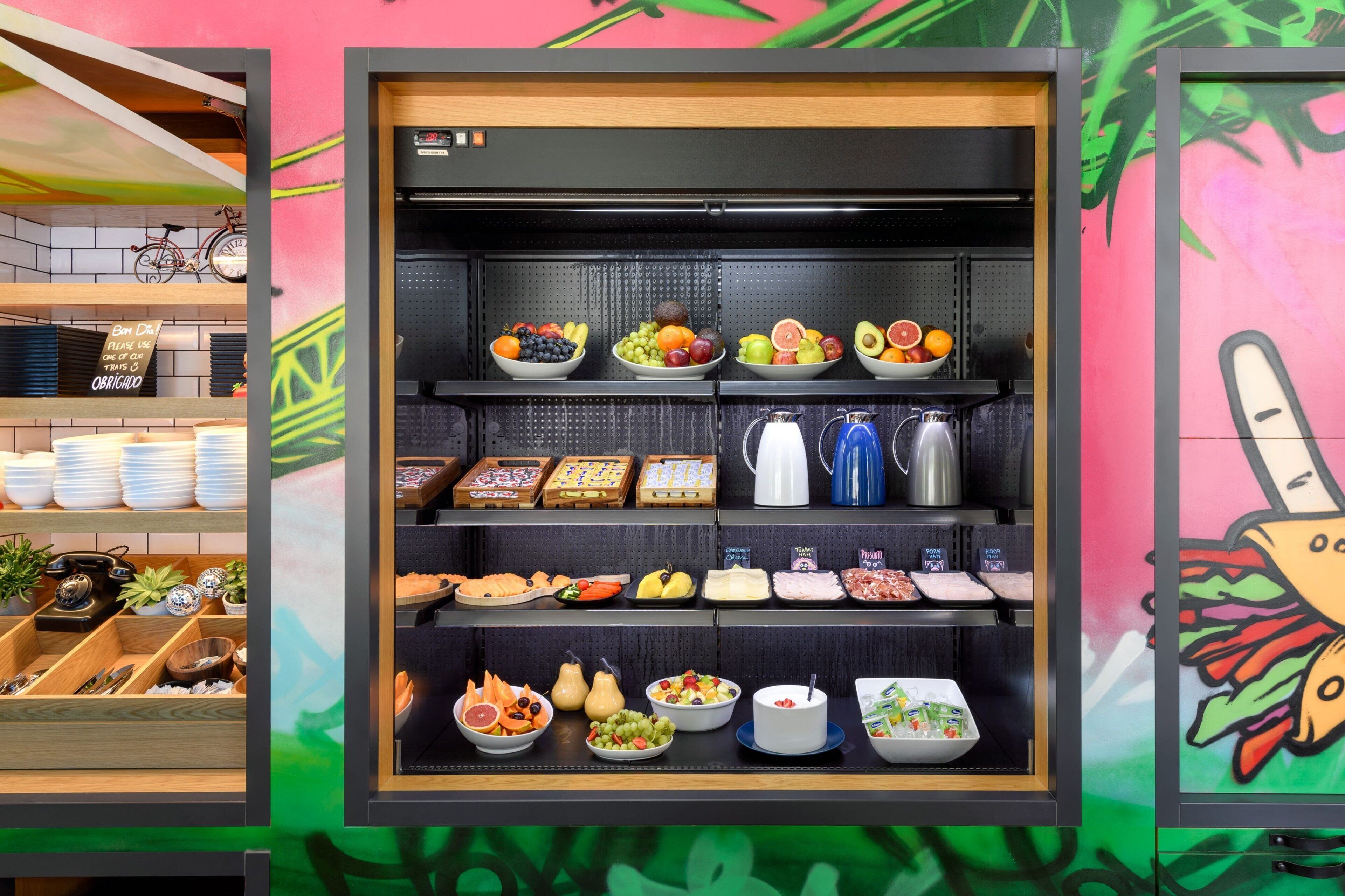 A food display with various fruits, cheeses, and condiments.