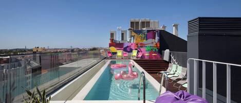 Una piscina al aire libre, sillones reclinables de piscina
