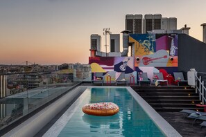Una piscina al aire libre, sillones reclinables de piscina