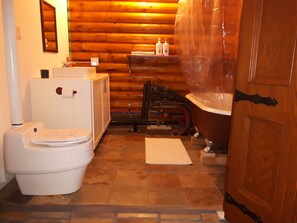 A bathroom with a toilet, a sink, and a bathtub. - Log cabin on the James River in Alberta (James River Bridge)