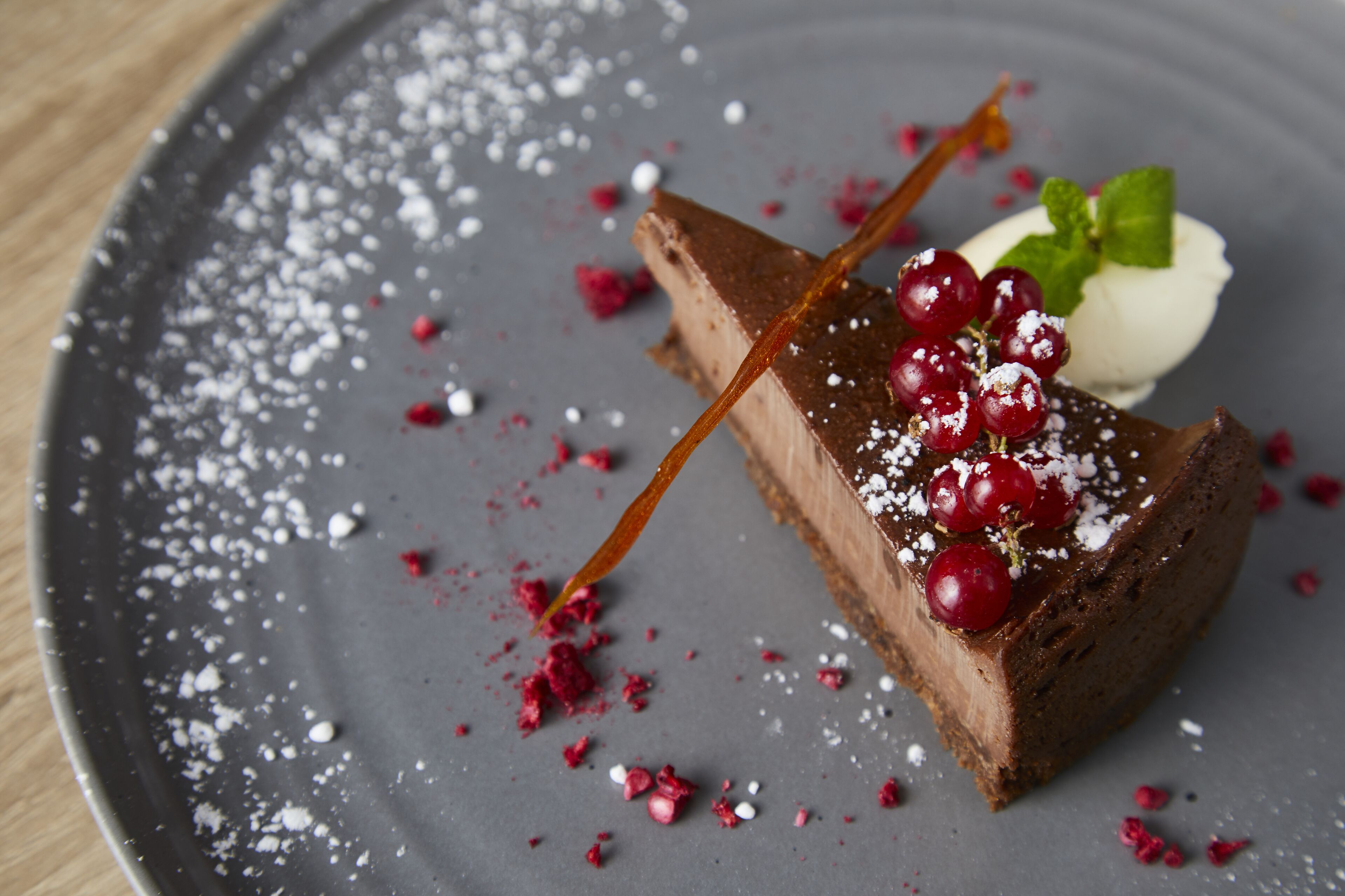 A slice of chocolate cake with berries and whipped cream on a plate.