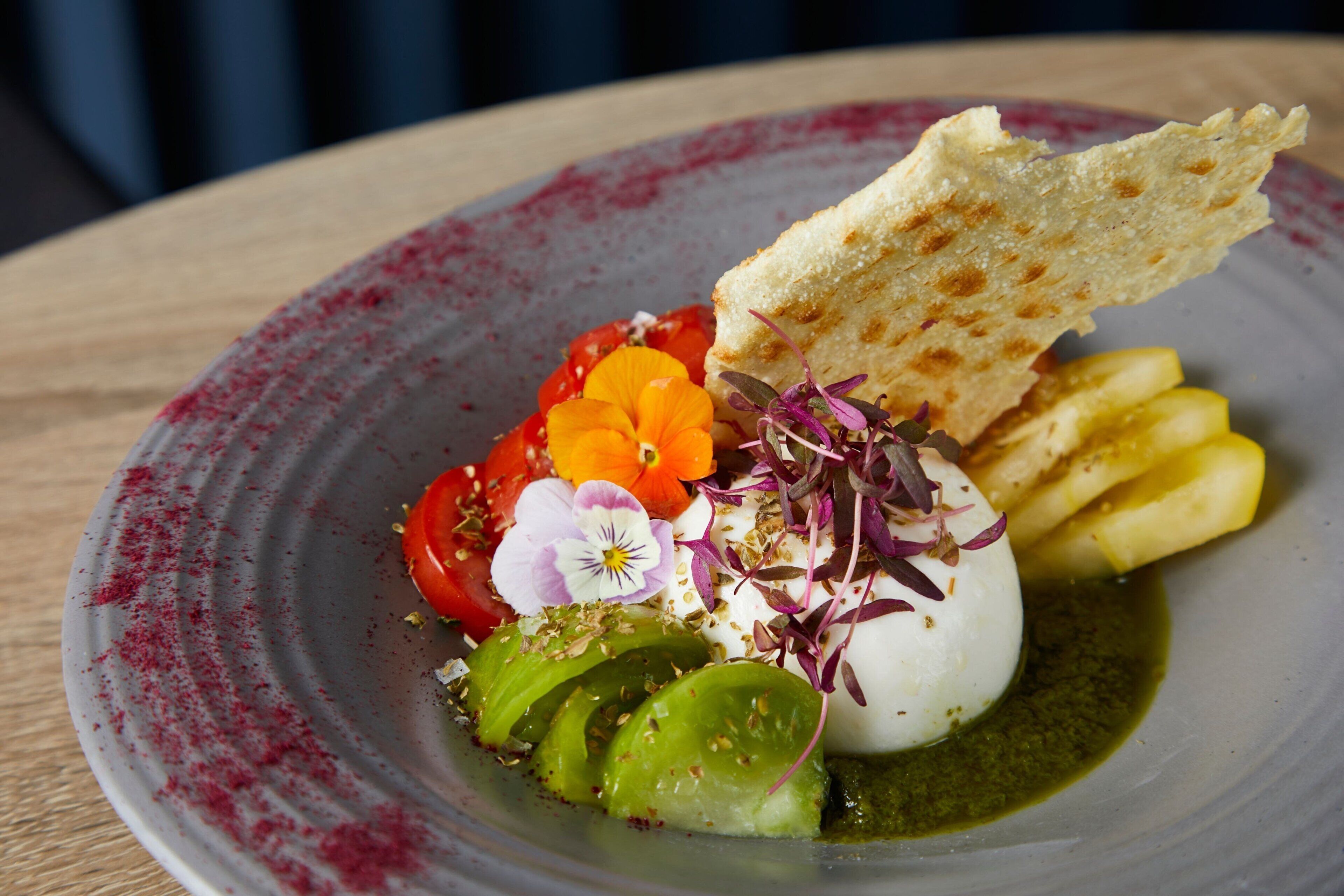 A plate with a variety of food items including a poached egg, tomatoes, greens, and bread.
