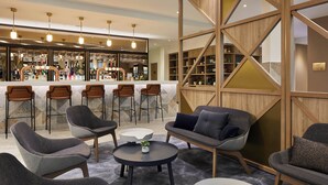 Un área de bar moderna con asientos y un separador de madera.
