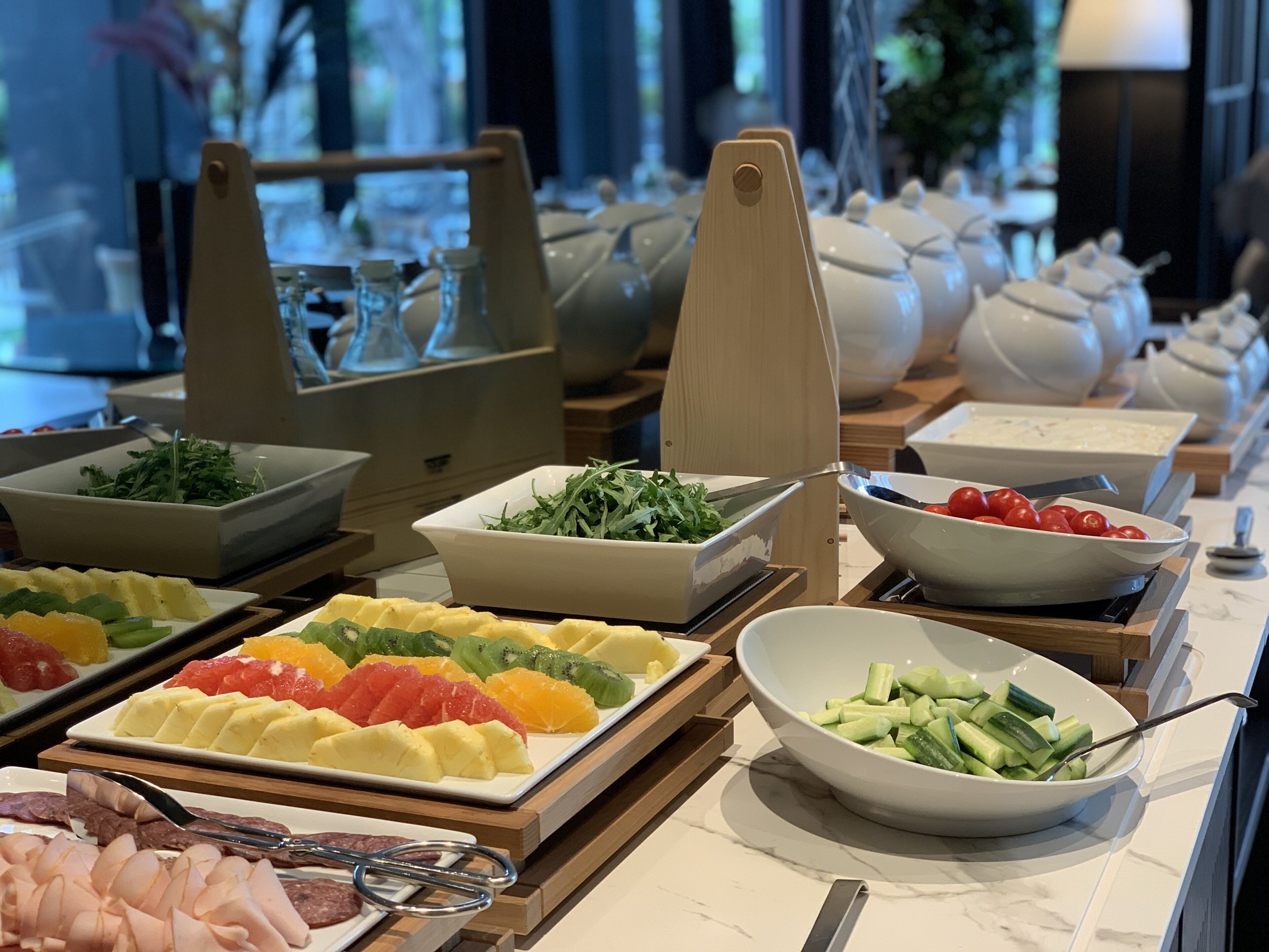 A buffet with various food items including fruits, vegetables, and meats.