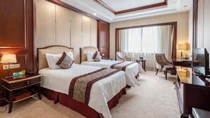 A hotel room with two beds, a desk, a chair, a television, and a large window. - Ningbo Sunny Hotel (Ningbo)