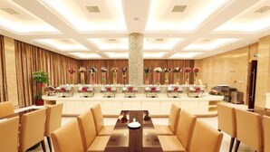 A modern hotel lobby with a central reception desk, a large seating area with sofas and a long table, and a decorative floral arrangement on the wall. - Ningbo Sunny Hotel (Ningbo)