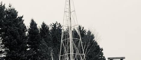 A windmill with a tractor parked nearby.
