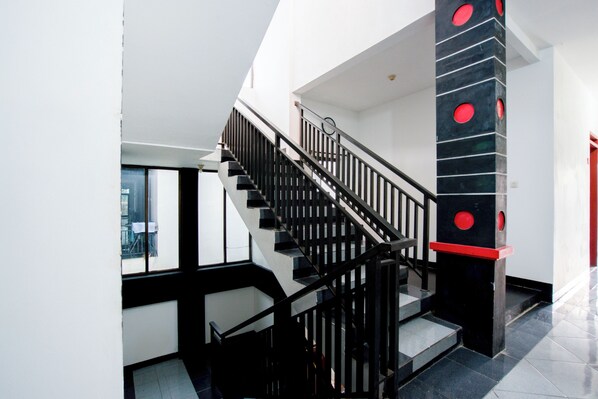 Staircase leads to an upper level in a modern space with a unique column design.
