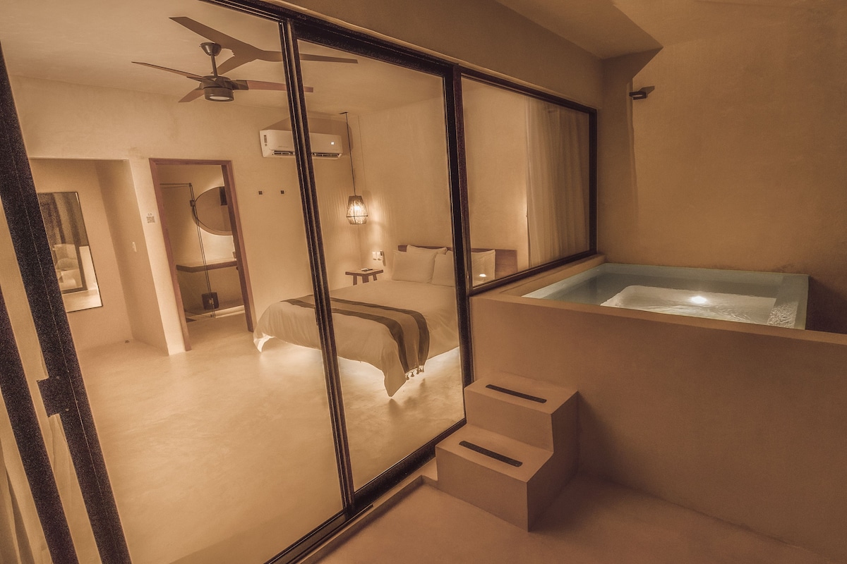 A modern bathroom with a glass-enclosed shower, a large mirror, and a built-in jacuzzi.