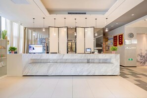 A modern reception desk with a marble top, a computer monitor, and a digital display. - Jinjiang Inn (Tianjin Zhongxin Eco-city) (Tianjin)