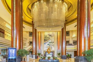 A spacious lobby with a large chandelier, a reception desk, and a staircase. - Dongdu Narada Grand Hotel (Yixing)