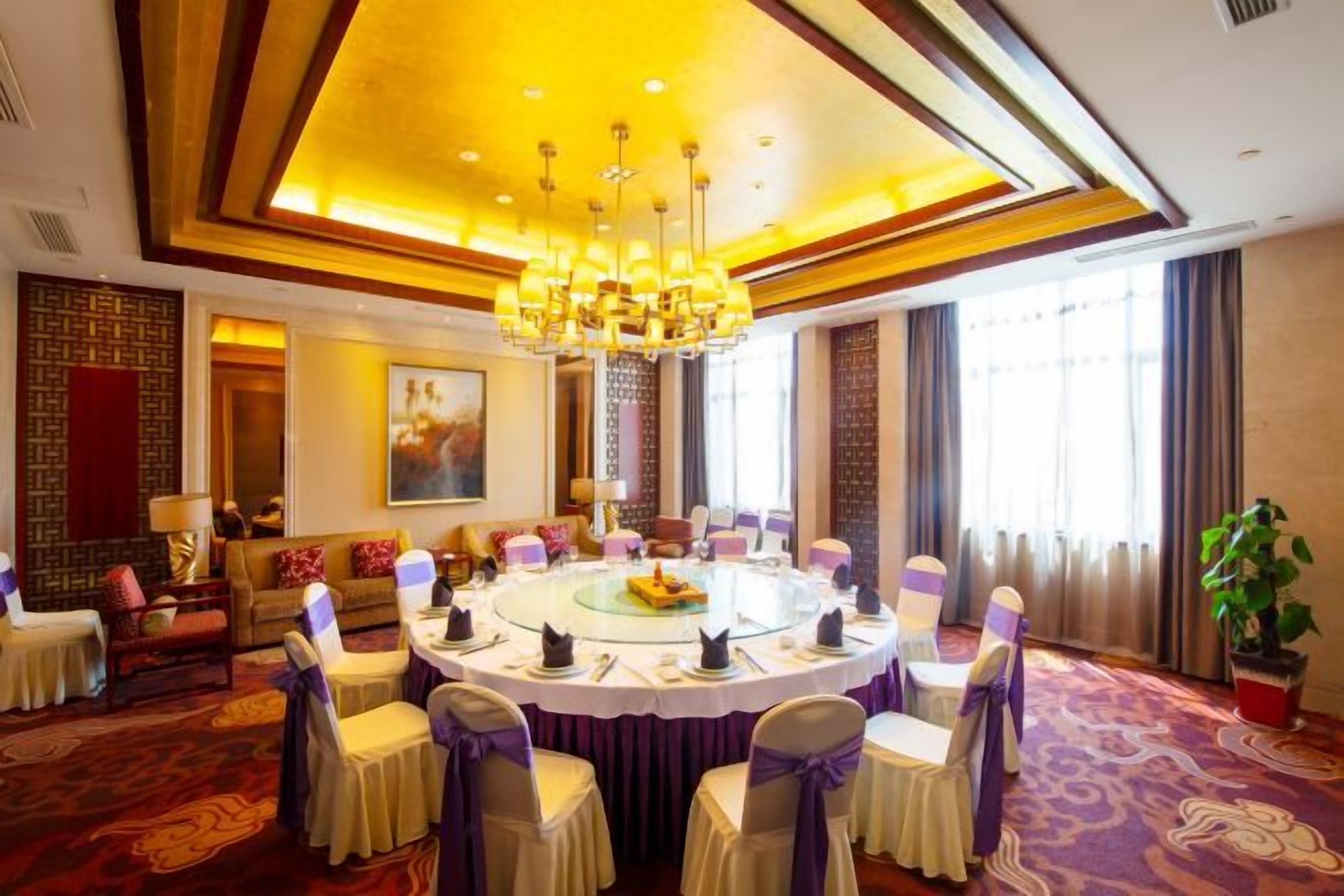 A conference room with a round table, chairs, and a chandelier.