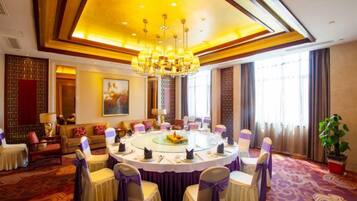 A conference room with a round table, chairs, and a chandelier.