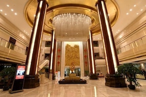 A spacious lobby with a grand chandelier, tall columns, and a central decorative wall. - Dongdu Narada Grand Hotel (Yixing)