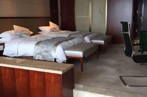 Una habitación de hotel con una cama grande, un banco y un escritorio.
