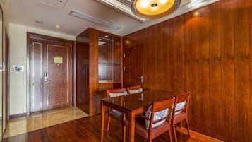 A conference room with a wooden table and chairs, a door, and a light fixture.