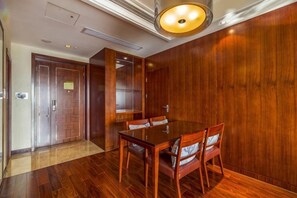 A conference room with a wooden table and chairs, a door, and a light fixture.