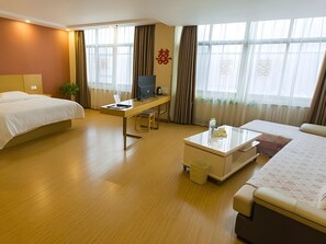 Une chambre d’hôtel équipée d’un lit, d’un bureau, d’une chaise et d’une petite table basse.